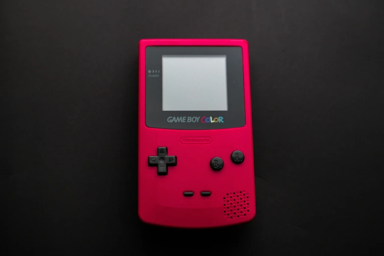 a pink gameboy sitting on top of a black table, colors red, on a gray background, handheld, colorful computer screen