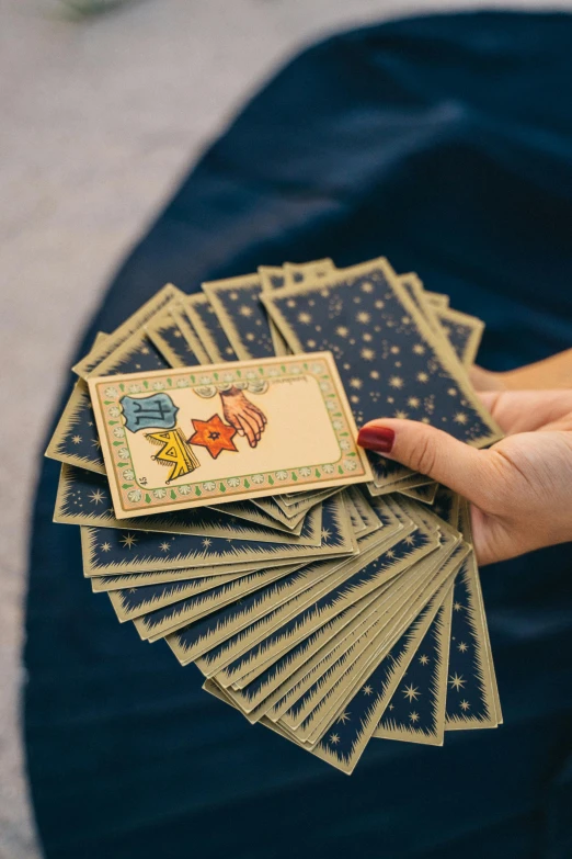 a woman holding a stack of playing cards, a hologram, by Julia Pishtar, unsplash, old-fashioned tarot card, children playing with pogs, lots of stars, subtle detailing