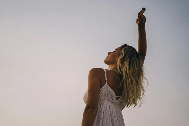 a woman in a white dress is flying a kite, pexels contest winner, armpit, goddess checking her phone, blonde, sunfaded