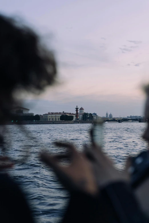 a couple of people that are standing in the water, a picture, by Alexander Runciman, happening, looking at the city, the photo was taken from a boat, late summer evening, viktoria gavrilenko