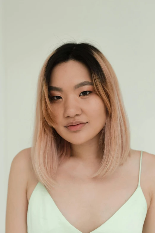 a woman in a green dress posing for a picture, a character portrait, inspired by helen huang, featured on reddit, realism, black to light pink fade hair, set on singaporean aesthetic, headshot profile picture, light tan