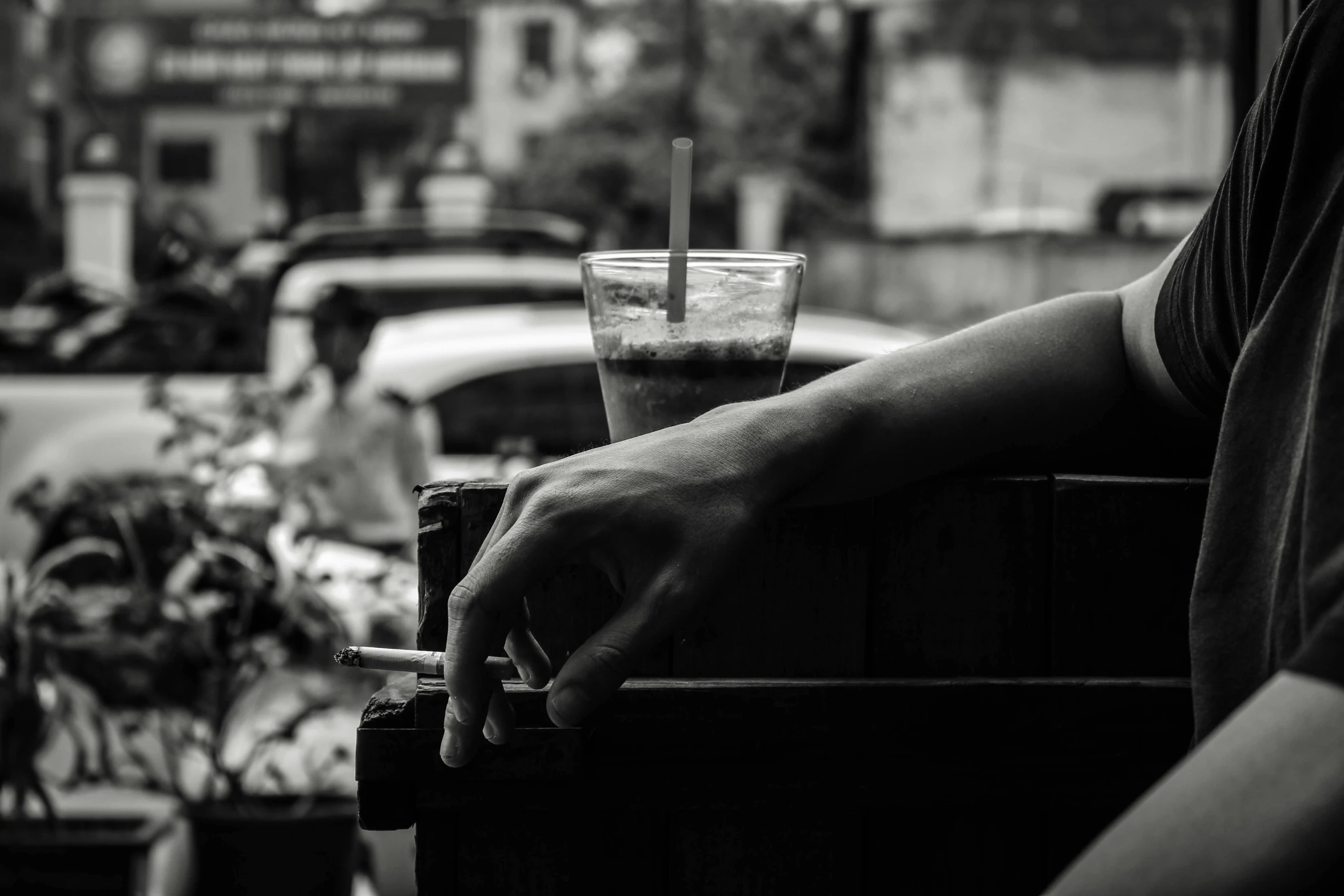 a black and white photo of a person holding a drink, by Tamas Galambos, pexels contest winner, realism, resting, ice coffee, medium format, summer day