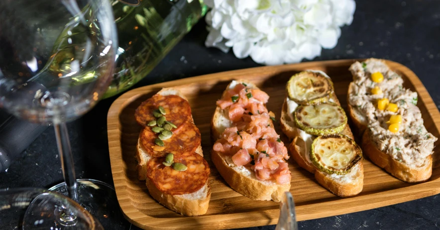 a close up of a plate of food on a table, holding a baguette, on a wooden tray, battle toast, trio