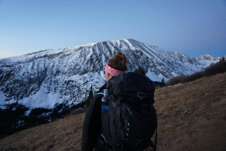 a person with a backpack looking at a mountain, by Emma Andijewska, unsplash contest winner, high above treeline, cold freezing nights, profile image, colorado mountains