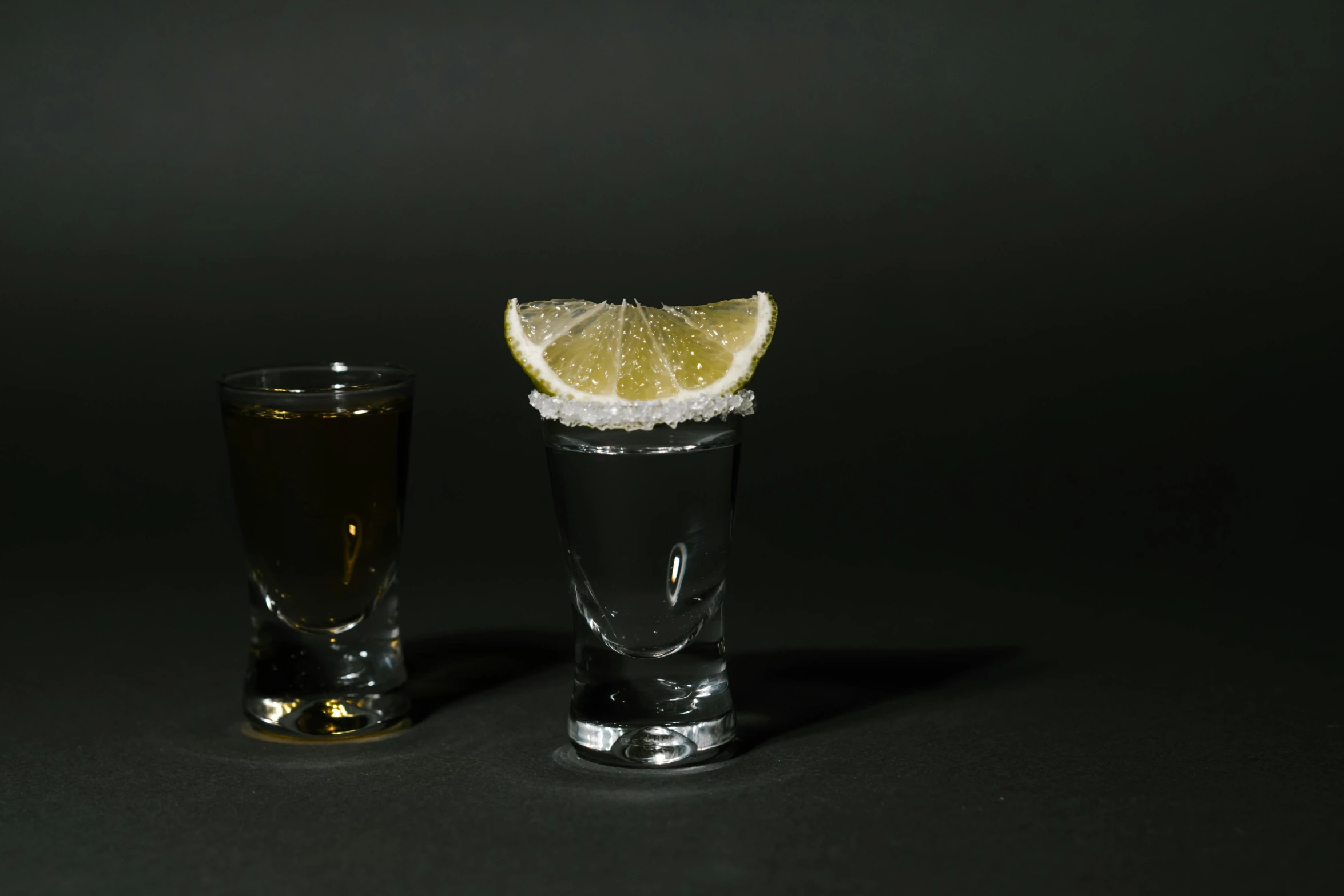 a couple of shot glasses sitting next to each other, 🍸🍋, medium-shot, mexican standoff, highly polished