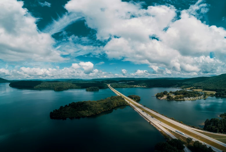 a long bridge over a large body of water, by Ben Thompson, pexels contest winner, hurufiyya, 4 k cinematic panoramic view, alabama, clouds around, high angle view