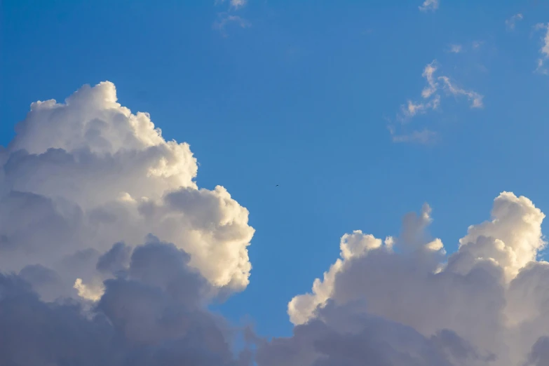 a jetliner flying through a cloudy blue sky, unsplash, postminimalism, cotton candy clouds, today\'s featured photograph 4k, cumulus, evening lighting