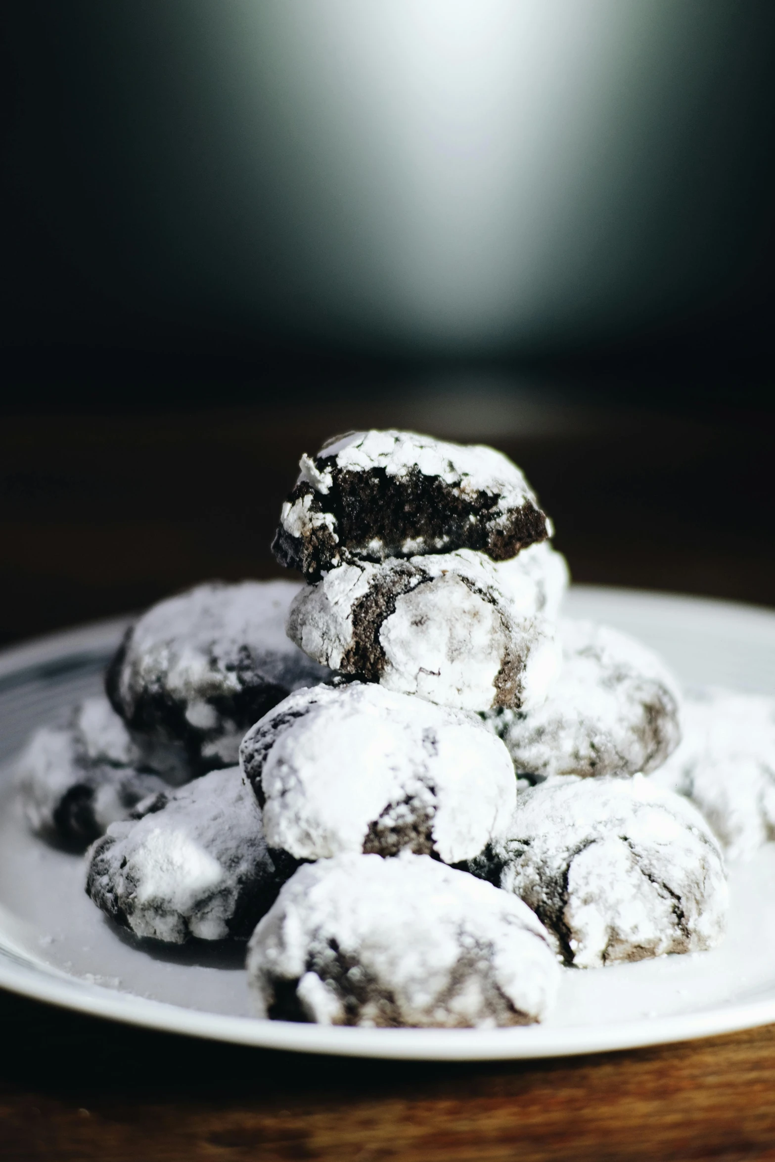 a white plate topped with cookies covered in powdered sugar, a portrait, in gunmetal grey, voluminous, stacked, chocolate. rugged