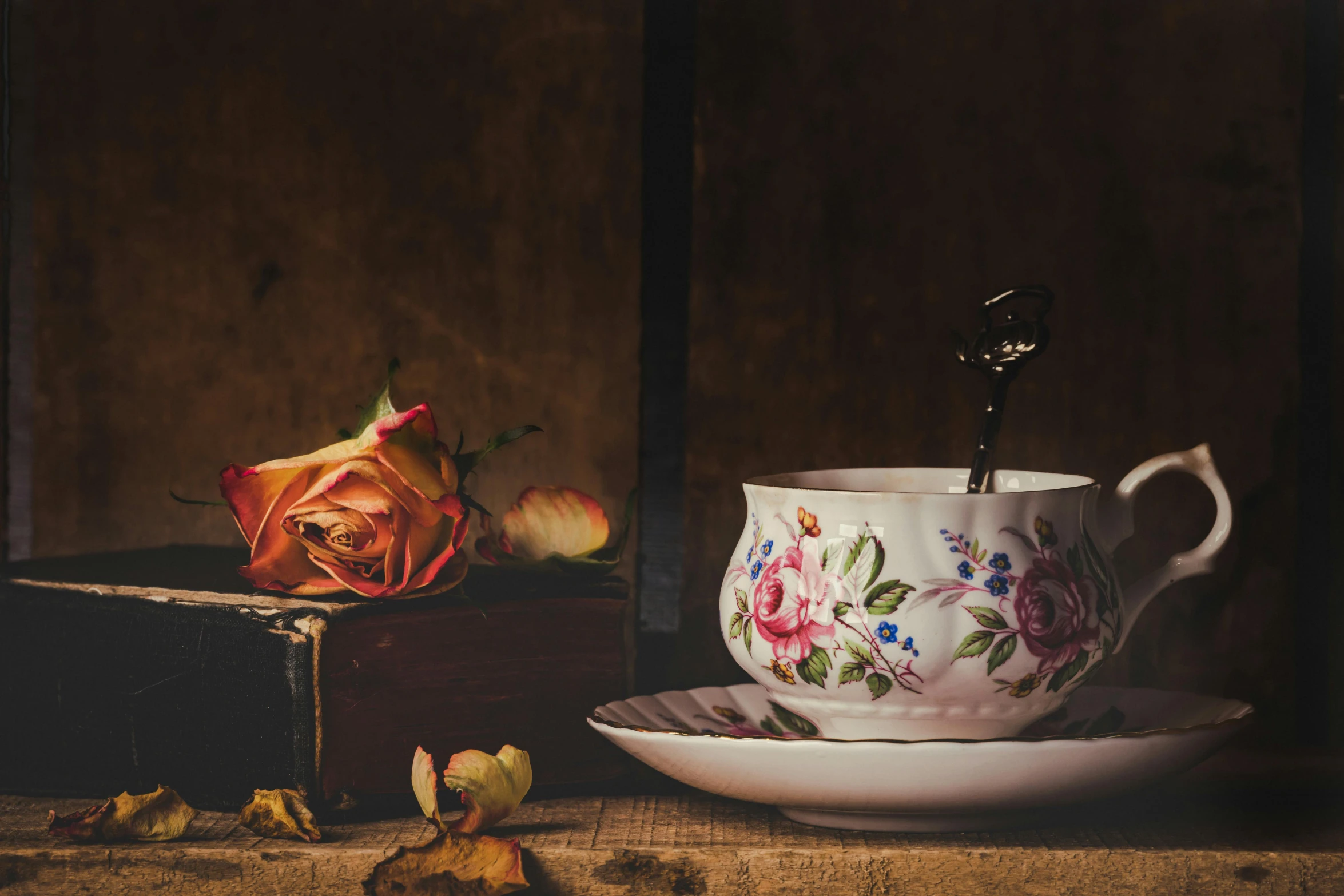 a tea cup sitting on top of a saucer next to a book, a still life, inspired by Jean-Baptiste Pater, pexels contest winner, photo of a rose, album cover, steampunk fiction, background image