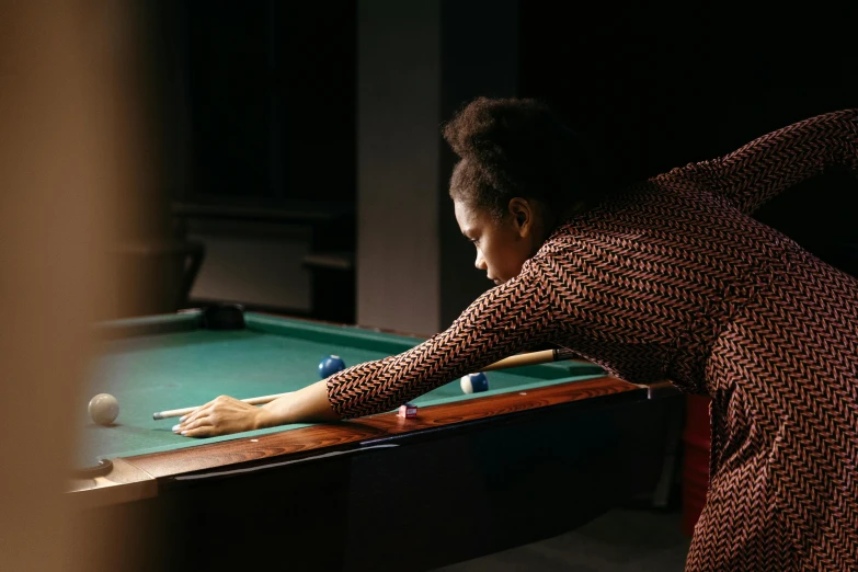 a woman in a dress playing a game of pool, pexels contest winner, lupita nyong'o, moody feel, thumbnail, tessa thompson inspired