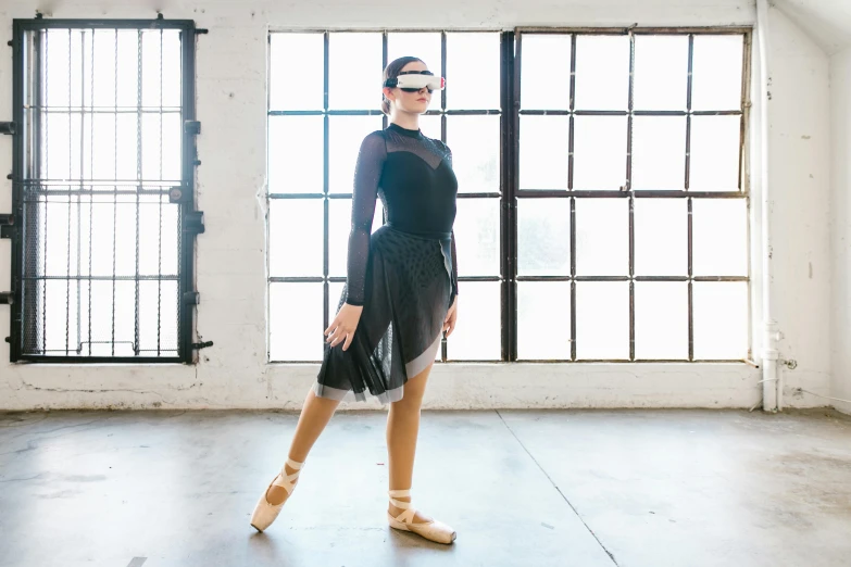 a woman that is standing in a room, inspired by Elizabeth Polunin, unsplash, opaque visor, dressed as a ballerina, wearing bionic implants, blind