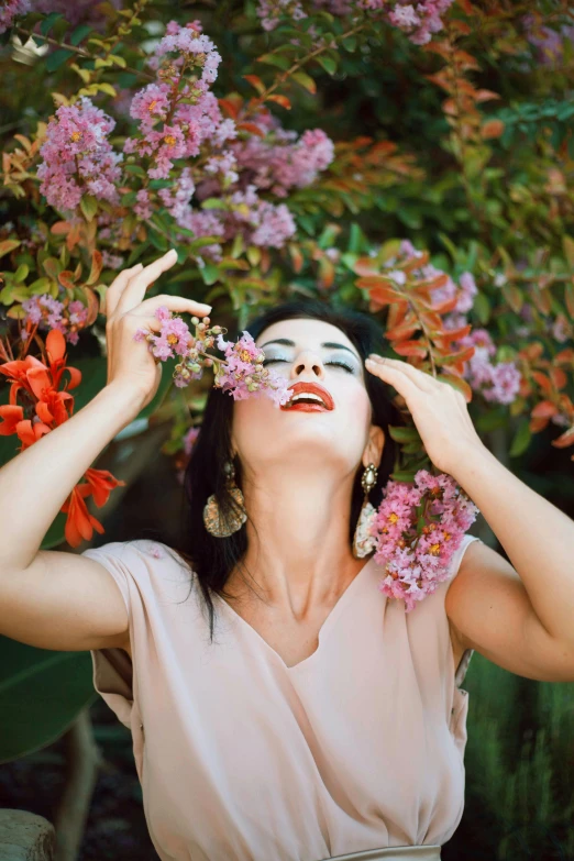 a woman standing in front of a bunch of flowers, a colorized photo, pexels contest winner, aestheticism, brunette fairy woman stretching, hands on face, lush surroundings, mai anh tran