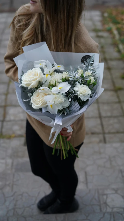 a woman holding a bunch of white flowers, by Niko Henrichon, pexels contest winner, 15081959 21121991 01012000 4k, in city street, gray canvas, message