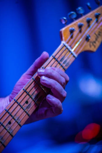 a close up of a person holding a guitar, by Dave Melvin, blue gloves, wearing presidential band, play of light, blues