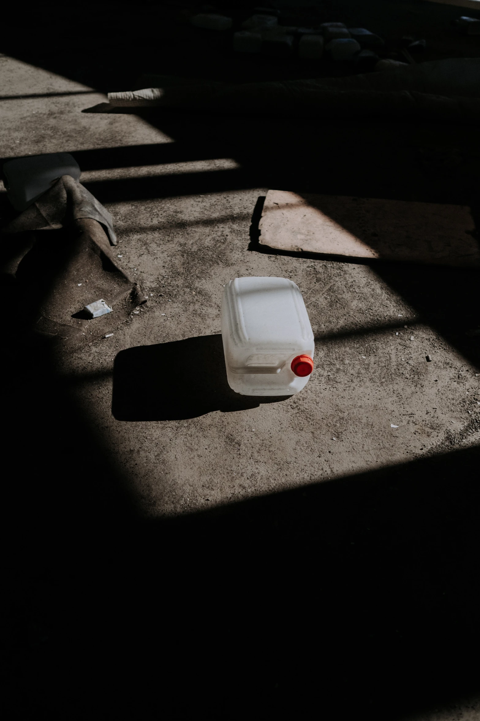 a white container sitting on top of a cement floor, pexels contest winner, liquid light, difraction from back light, 4l, ignant