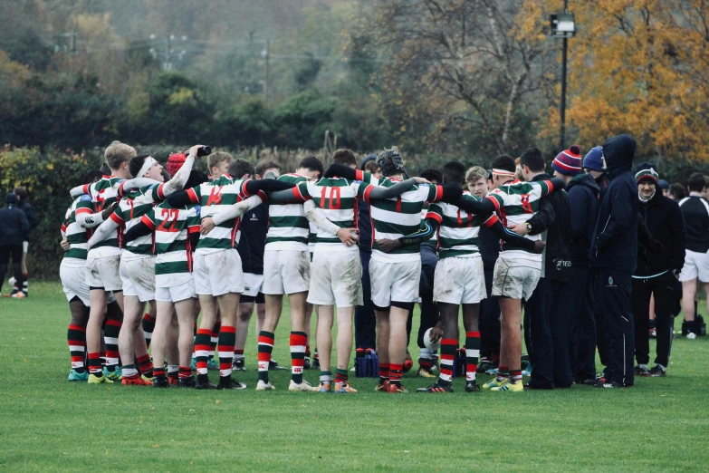 a group of men standing on top of a lush green field, sports photo, private school, green and red, header