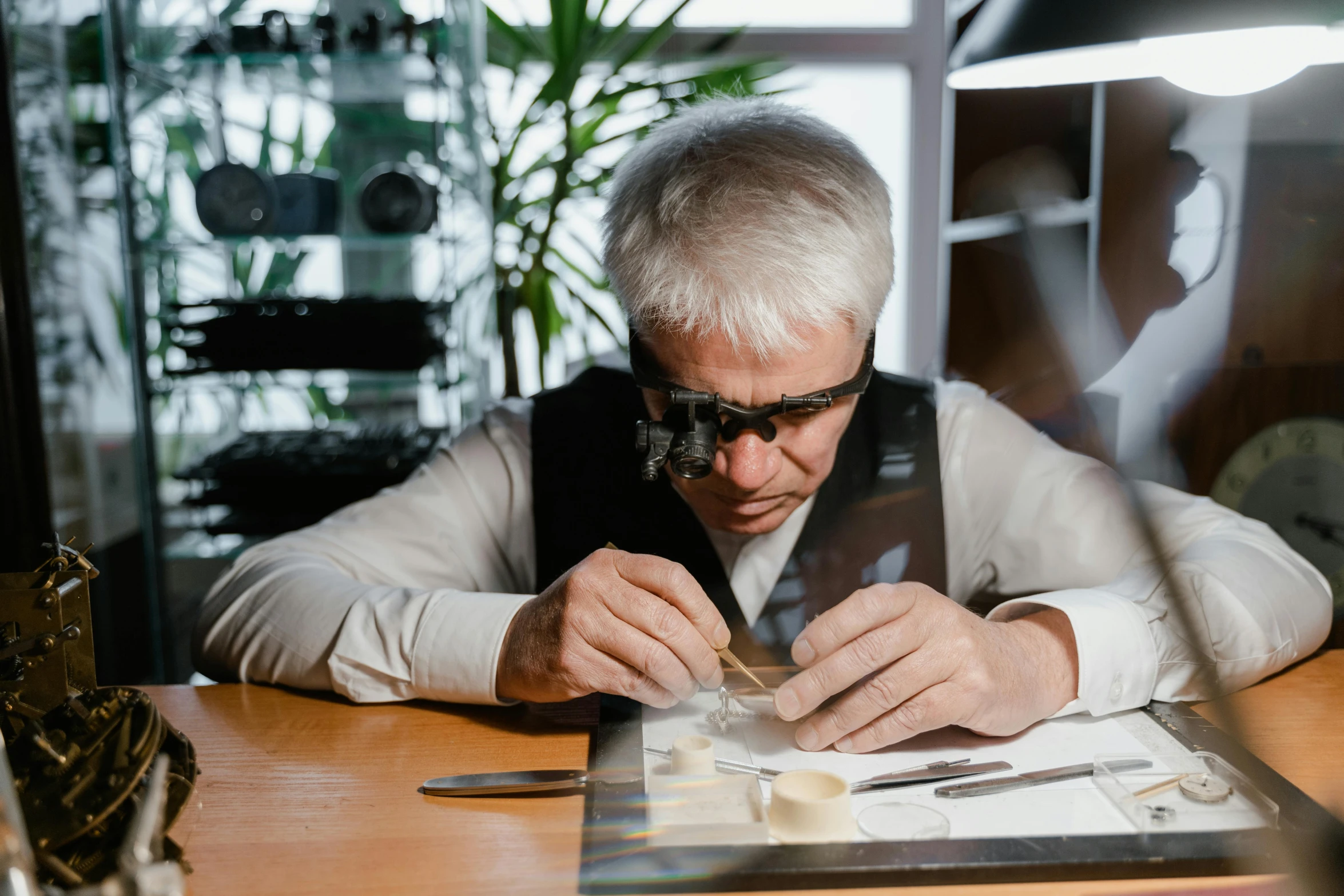 a man sitting at a table working on a piece of paper, by Adam Marczyński, pexels contest winner, specimens in glasses, van cleef & arpels style, avatar image, professional gunsmithing