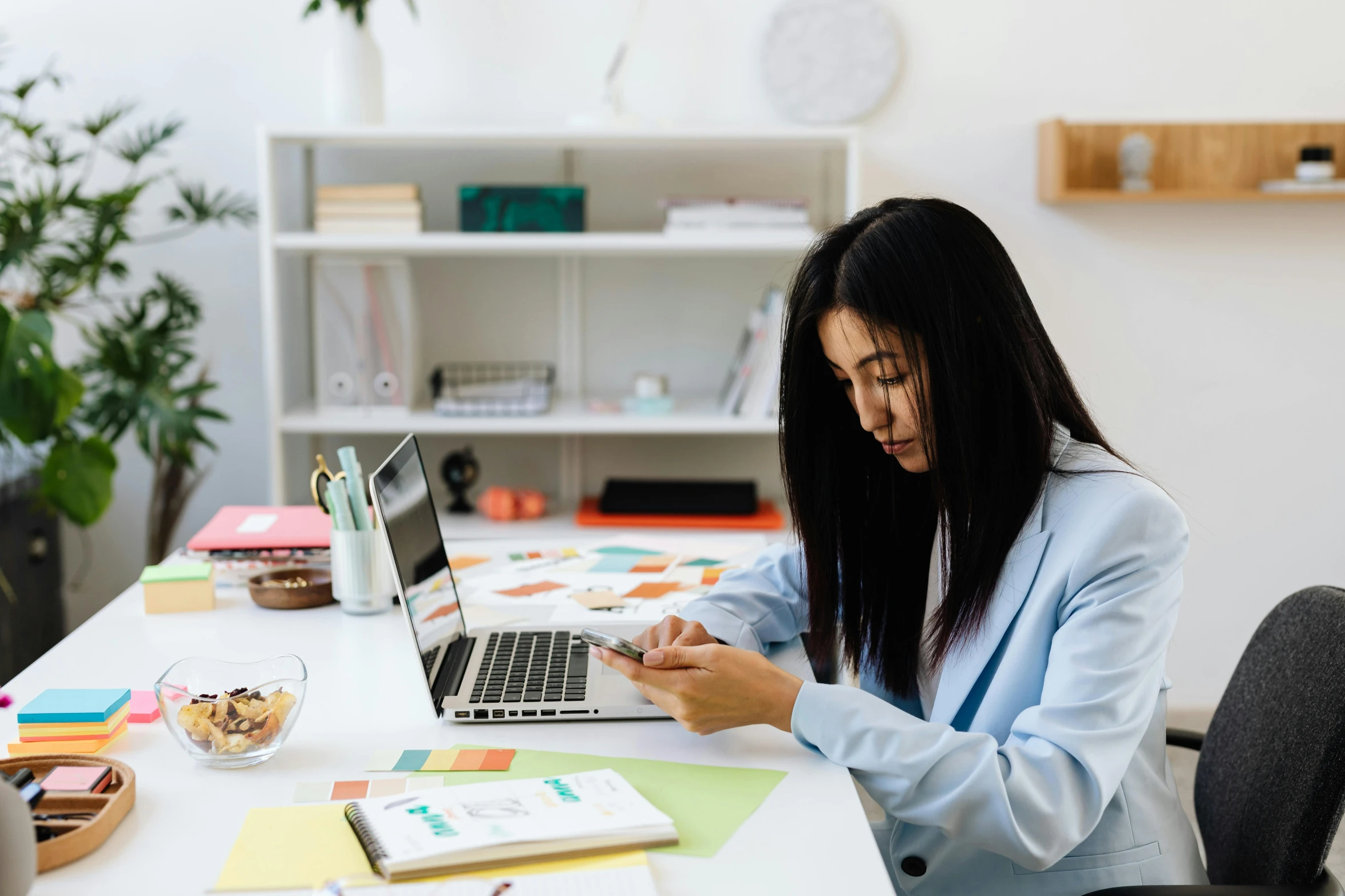 a woman sitting at a desk using a laptop computer, trending on pexels, asian women, multicoloured, office clothes, 1 2 9 7