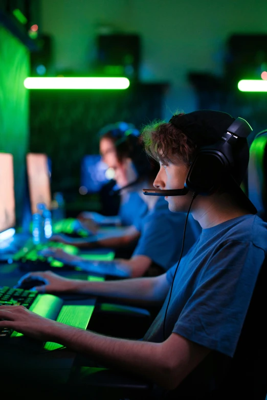 a group of people sitting in front of computers, playing video games, blue and green light, header, 2 5 6 x 2 5 6 pixels