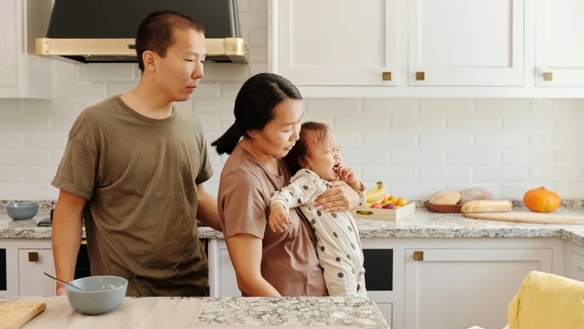 a man and woman holding a baby in a kitchen, pexels contest winner, asian descent, animation still, manuka, struggling