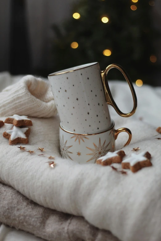 a coffee cup sitting on top of a pile of blankets, gold decorations, starlight, organic ceramic white, cosy