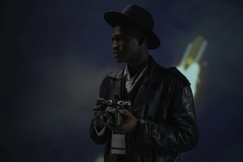 a man in a hat holding a camera, inspired by Gordon Parks, afrofuturism, night sky, adut akech, **cinematic, production photo