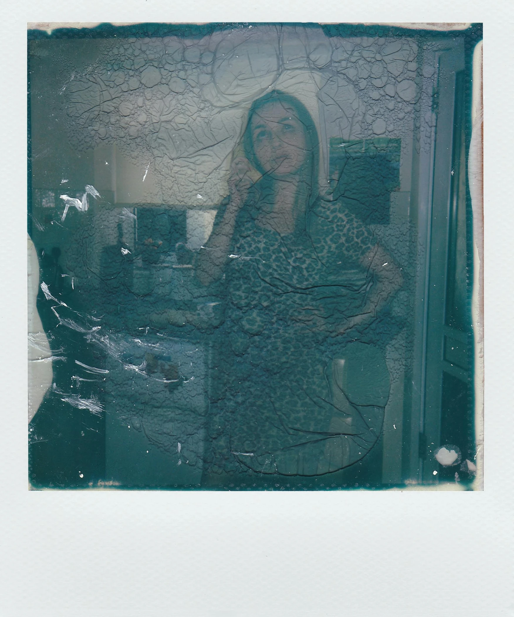 a woman taking a picture of herself in a mirror, a polaroid photo, inspired by Elsa Bleda, scratched photo, blueish, in the kitchen, translucent sss xray