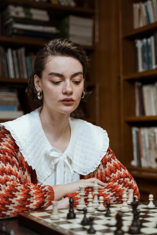 a woman playing a game of chess in a library, an album cover, inspired by Louisa Matthíasdóttir, trending on unsplash, mannerism, portrait sophie mudd, disappointed, academic clothing, close-up portrait film still