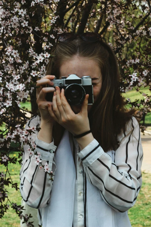 a woman taking a picture of a tree with a camera, a picture, pexels contest winner, girl in flowers, dslr photo of a pretty teen girl, half - length photo, eva elfie