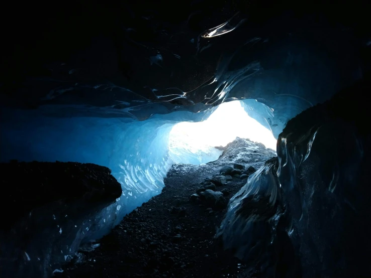 a light at the end of an ice cave, an album cover, pexels contest winner, black and blue color scheme, thumbnail, deep black, beautiful daylight