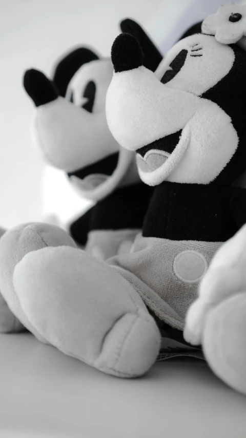 a couple of stuffed animals sitting next to each other, a cartoon, inspired by Luigi Kasimir, unsplash, in black and white, mickey mouse, closeup - view, cel - shaded