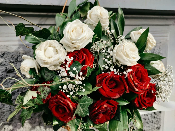 a bouquet of red and white roses in a vase, by Elsie Few, unsplash, romanticism, elegant highly detailed, over the shoulder view, romantic greenery, flowy
