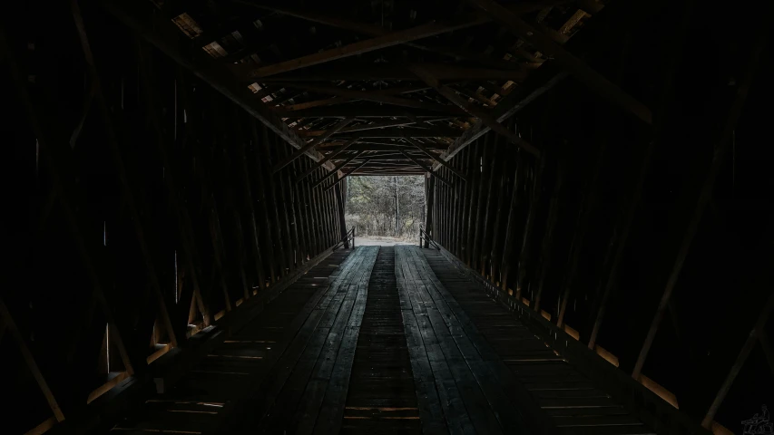 the inside of a wooden covered bridge at night, an album cover, by Andrew Domachowski, unsplash contest winner, it's getting dark, black, preserved historical, interior of a small