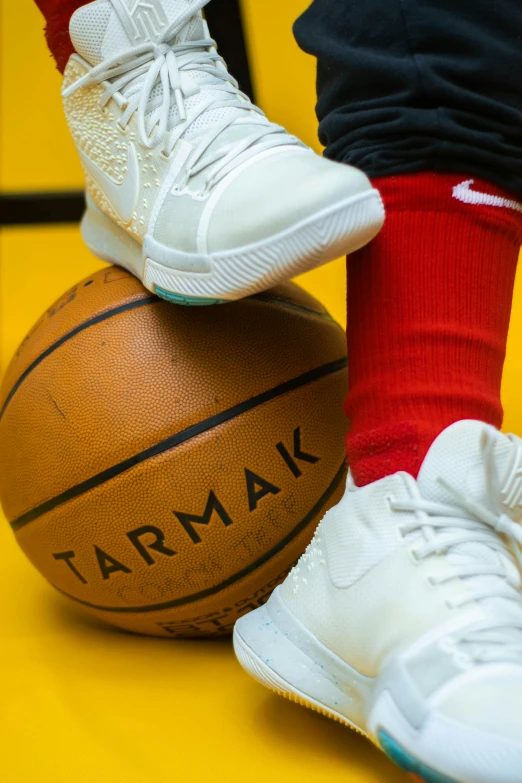 a person standing on top of a basketball ball, socks, arian mark, foot wraps, up close