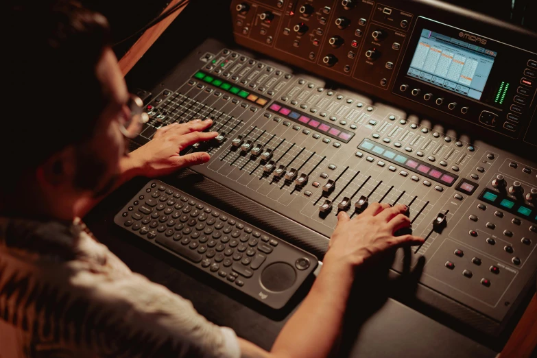 a man that is sitting in front of a mixer, profile image, brown, digital tech effects, female