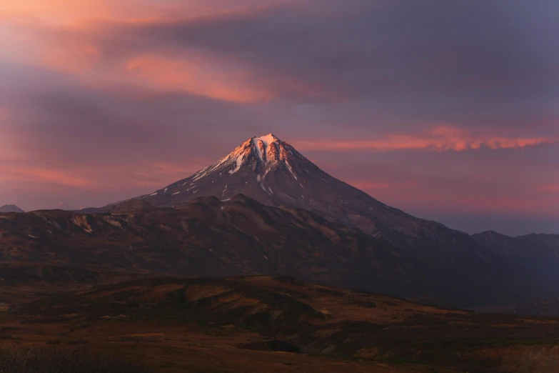 a mountain covered in snow under a cloudy sky, an album cover, unsplash contest winner, hurufiyya, pink golden hour, active volcano, late summer evening, azamat khairov