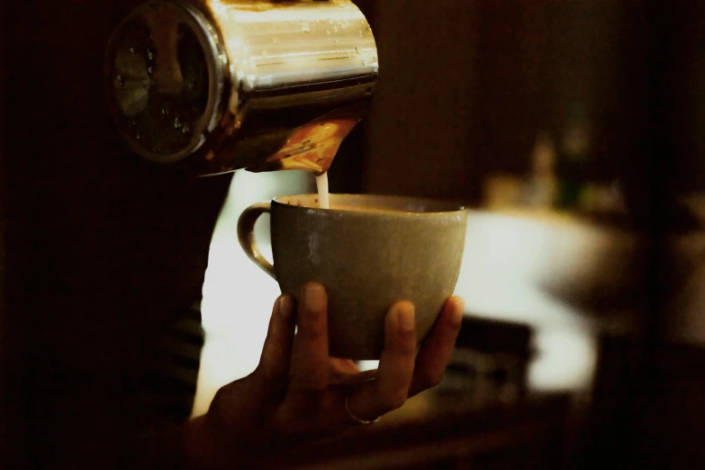 a person is pouring a cup of coffee, inspired by Elsa Bleda, unsplash, nightcap, aussie baristas, thumbnail, vintage photo