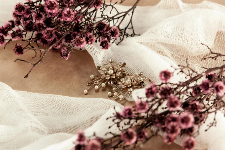 a bunch of flowers sitting on top of a white cloth, featured on pinterest, baroque, detailed jewellery, sepia toned, wearing gilded ribes, detailed product shot