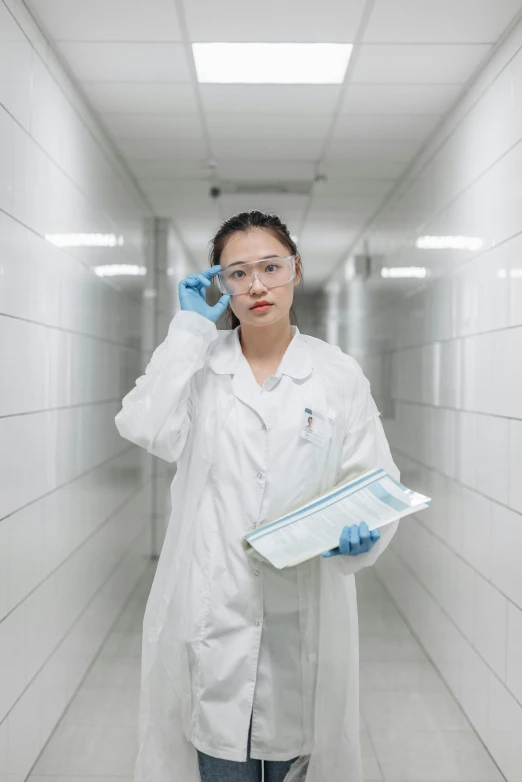 a woman in a lab coat talking on a cell phone, pexels contest winner, cai xukun, sterile minimalistic room, wearing gloves, asian women