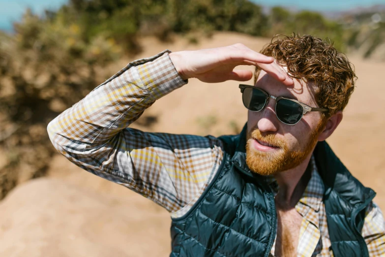 a man with a beard wearing a vest and sunglasses, by Ryan Pancoast, unsplash, renaissance, adam ondra, slightly sunny, patterned clothing, model wears a puffer jacket