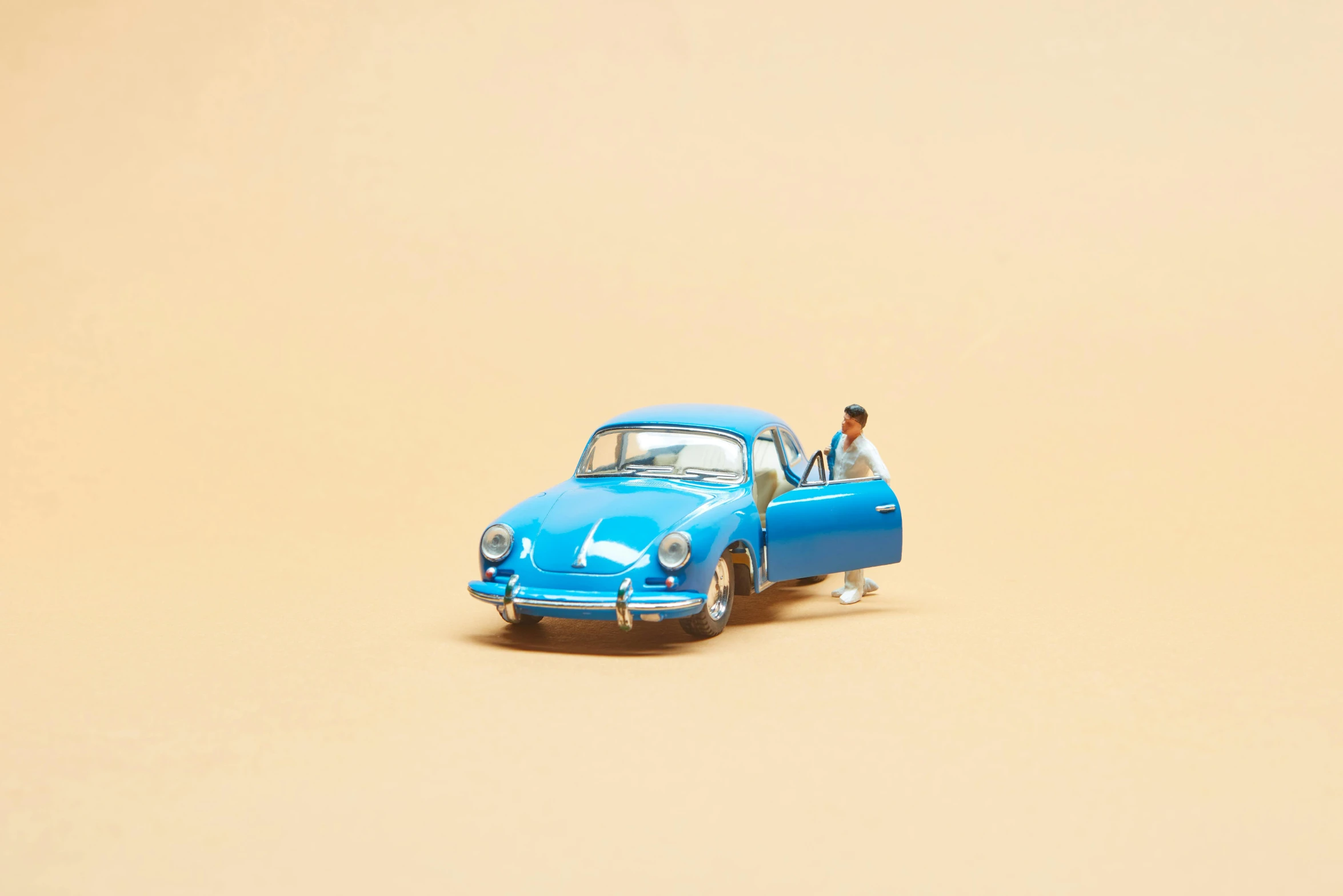 a blue toy car with a man sitting in the driver's seat, an album cover, unsplash, photorealism, pop up parade figure, slightly tanned, ilustration, porche