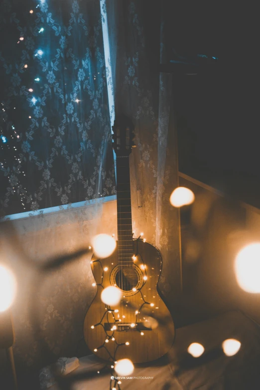 a guitar sitting on top of a table next to a window, inspired by Elsa Bleda, pexels contest winner, light and space, christmas lights, snapchat photo, studio photo, magically glowing