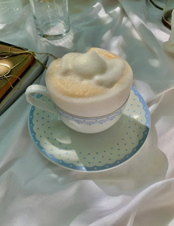 a cup of coffee sitting on top of a saucer, foamy bubbles, white and pale blue, cottagecore, detailed product image