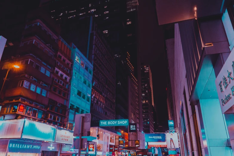 a city street filled with lots of tall buildings, inspired by Liam Wong, pexels contest winner, neon shops, purple and blue neon, desaturated, instagram post