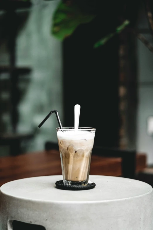 a glass of iced coffee sitting on top of a table, profile image, beige mist, thumbnail, milkshake