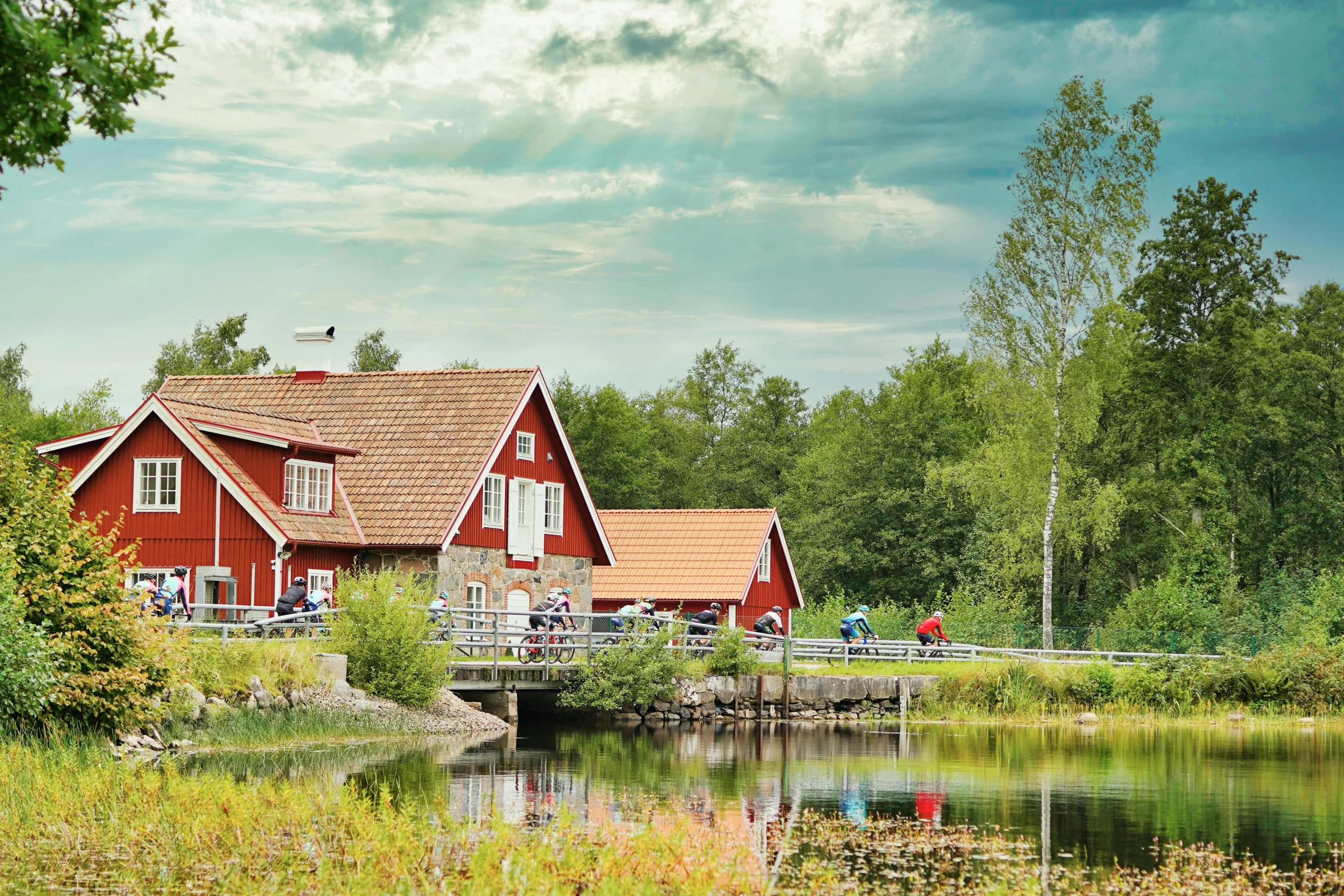 a red house sitting on top of a lush green field, by Jesper Knudsen, hurufiyya, waterfront houses, hideen village in the forest, family friendly, suntur