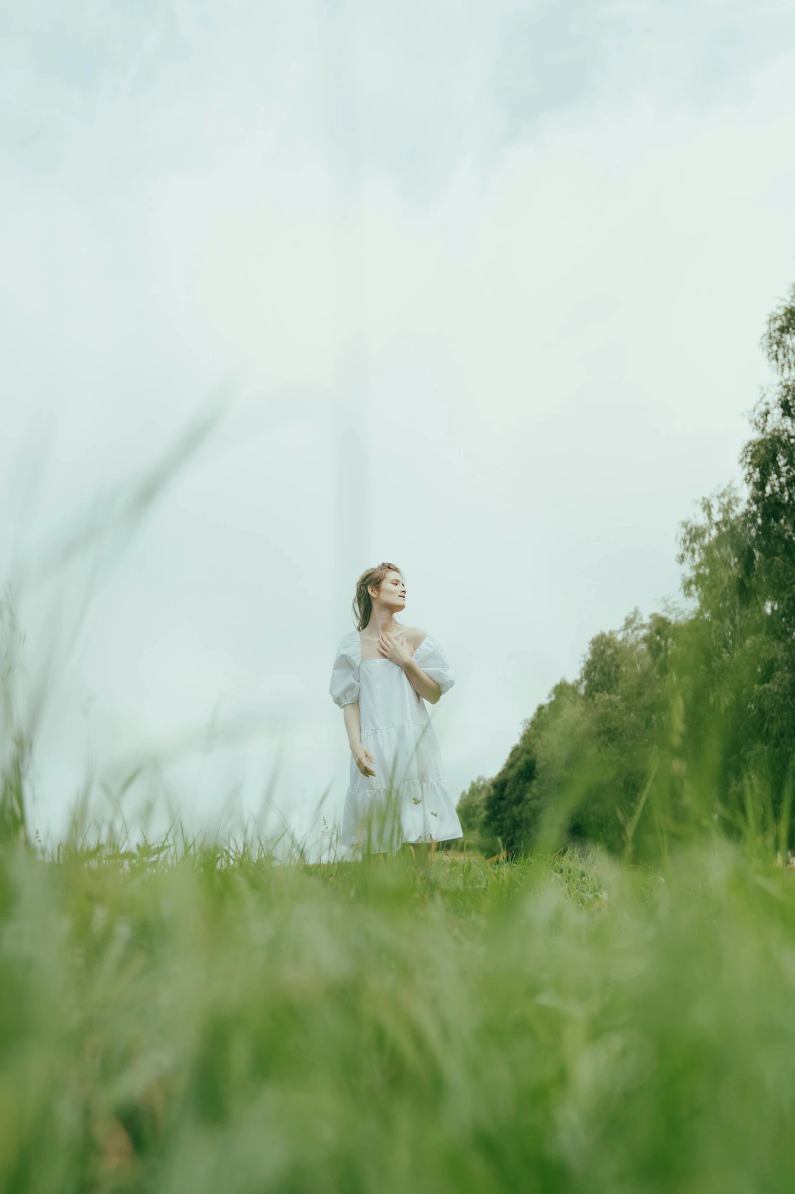 a woman standing on top of a lush green field, an album cover, inspired by William Stott, unsplash, renaissance, soft light.4k, movie still 8 k, overcast, nordic folk