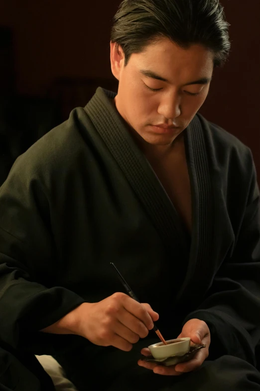 a man in a robe using a cell phone, a portrait, inspired by Zhao Mengfu, pexels contest winner, signing a bill, wearing dark green robes, joe taslim, promotional image