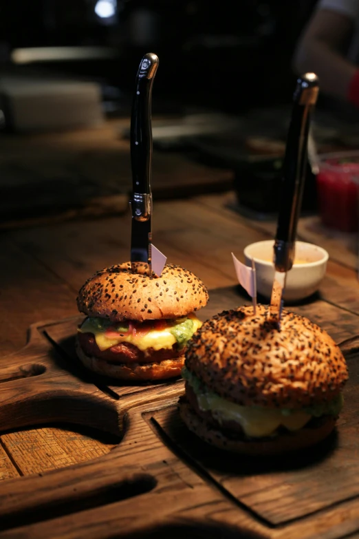 a couple of sandwiches sitting on top of a wooden cutting board, light show, serving burgers, david shing, trending photo