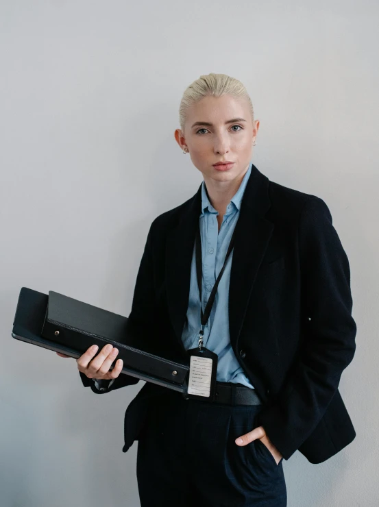 a woman in a business suit holding a briefcase, by Carey Morris, featured on reddit, neo-figurative, albino white pale skin, portrait of timothee chalamet, futuristic techwear, portrait featured on unsplash